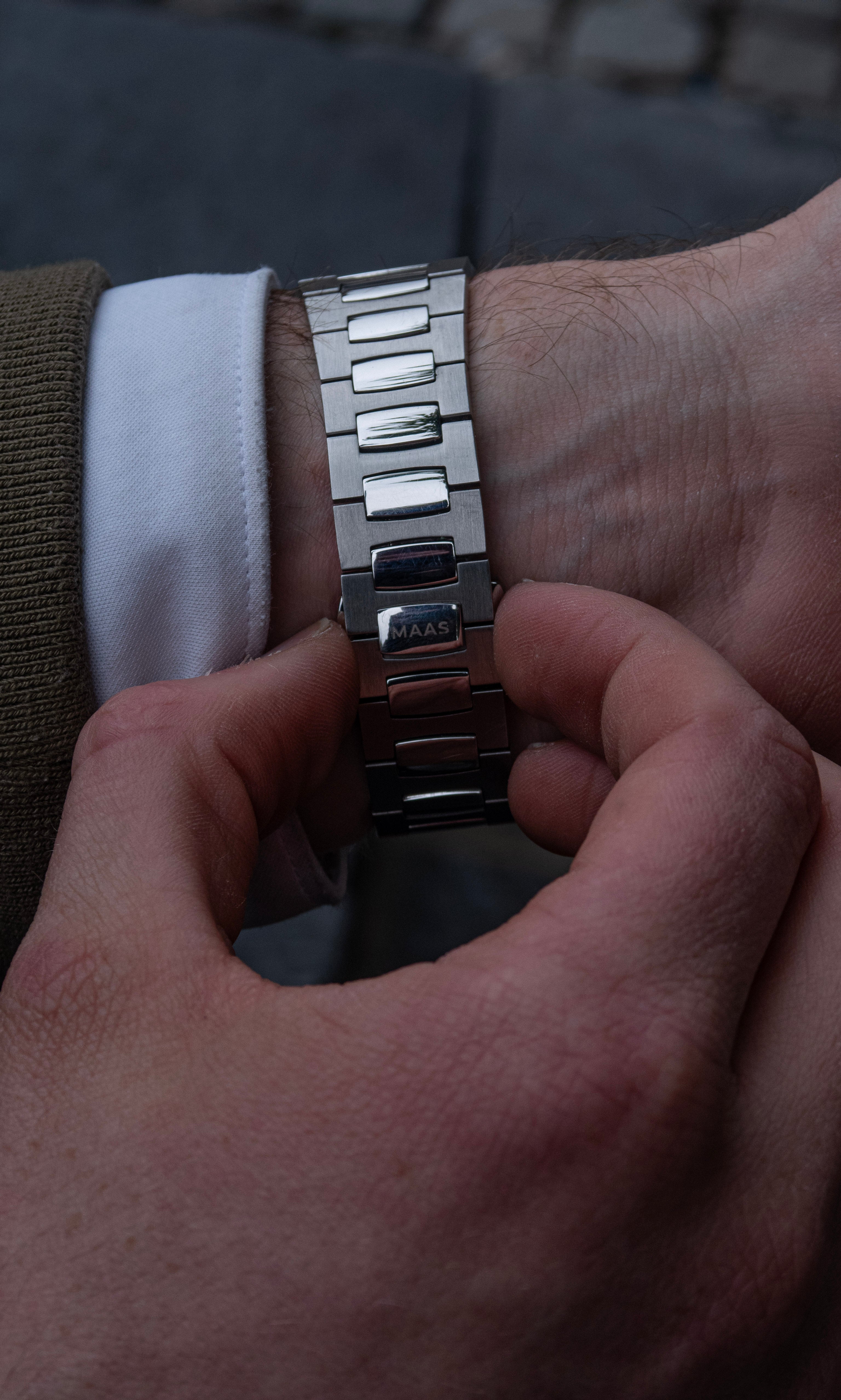 Close-up of a hand adjusting the bracelet on a wrist.